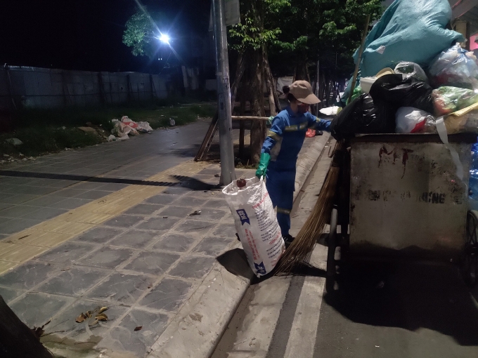 Gần 12 giờ đêm nhưng người phụ nữ ấy vẫn đang miệt mài với công việc phân loại và thu gom rác sinh hoạt. Ảnh: M.A